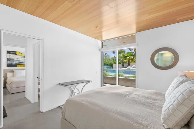 a bed room with two bed and a flat tv screen