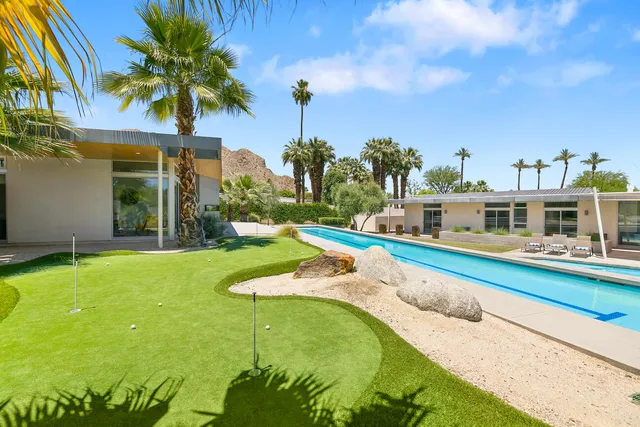 an aerial view of residential houses with outdoor space and ocean view