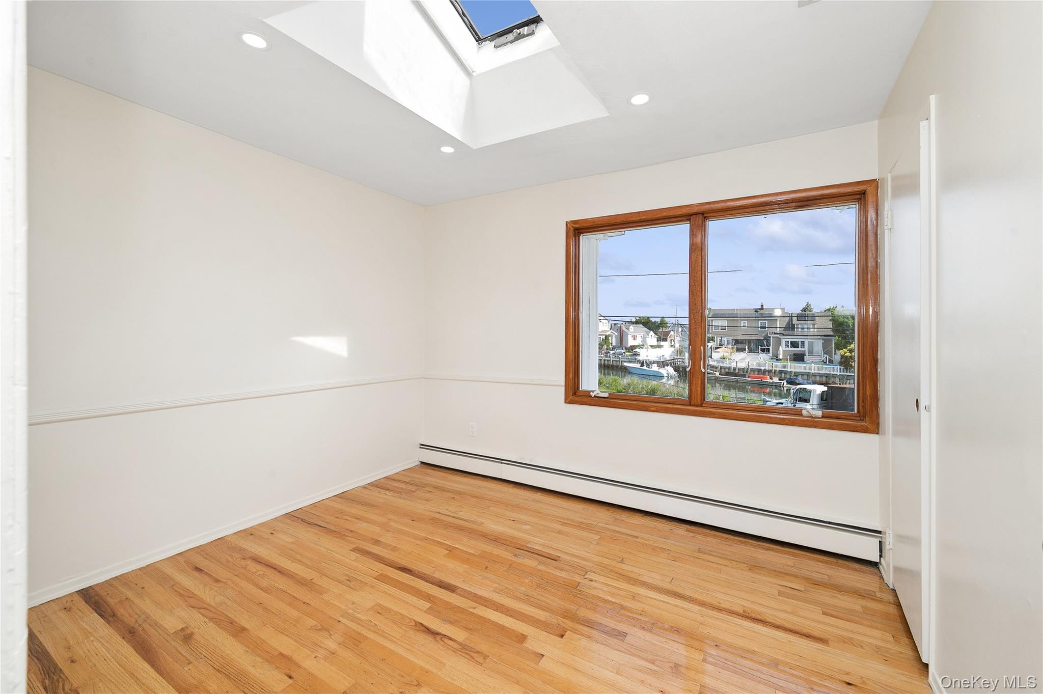 2625 Riverside Drive Wantagh, NY 11793 - Photo 15 of 20 an empty room with wooden floor and windows