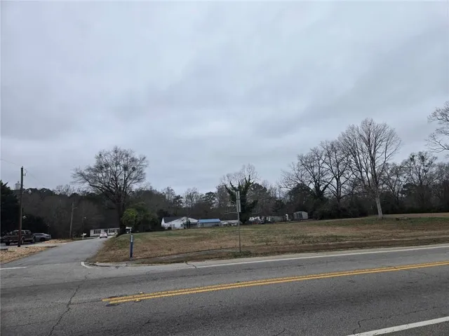 a view of a houses with a yard and road