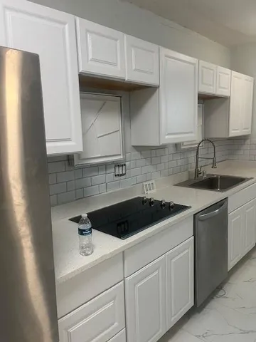 a kitchen with white cabinets and a sink