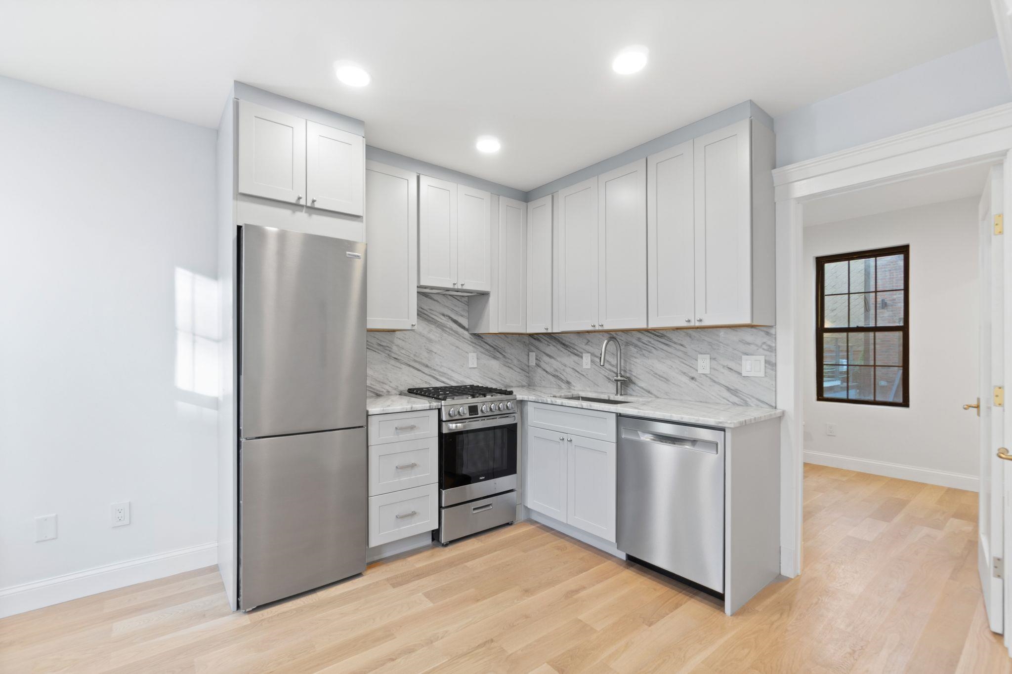 82 Colgate Street, Unit 1 Jersey City, NJ 07302 - Photo 3 of 13 a kitchen with stainless steel appliances granite countertop a refrigerator a stove a sink and a microwave