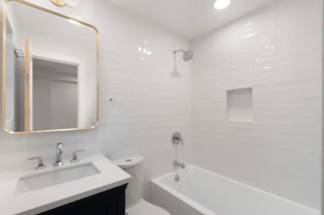 a bathroom with a sink mirror and a bathtub