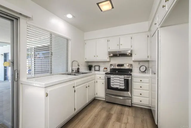 a kitchen with white cabinets and appliances