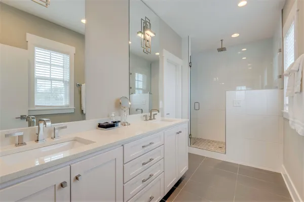 a bathroom with a double vanity sink and mirror with shower