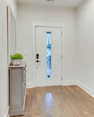 an empty room with wooden floor and mirror