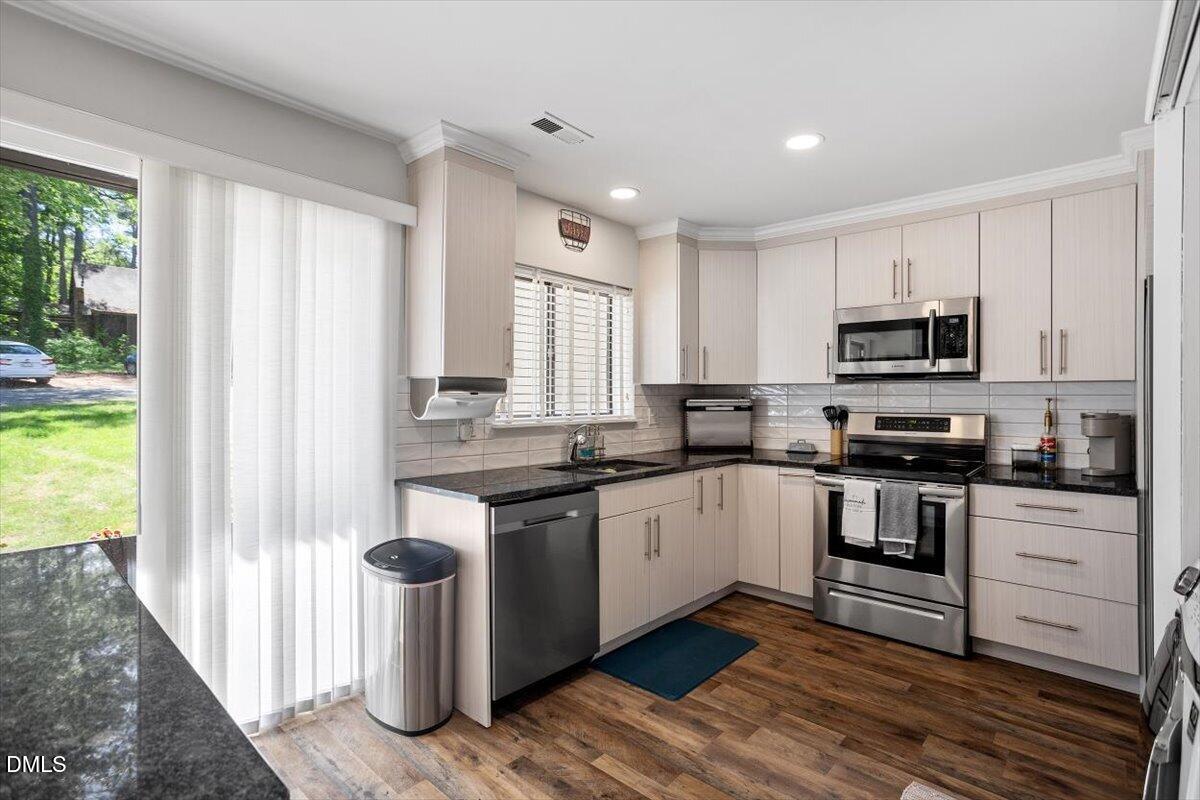 5045 Tall Pines Court Raleigh, NC 27609 - Photo 6 of 37 a kitchen with stainless steel appliances granite countertop a stove a sink and a microwave