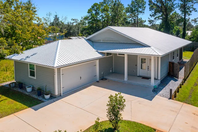 a aerial view of a house with yard and furniture