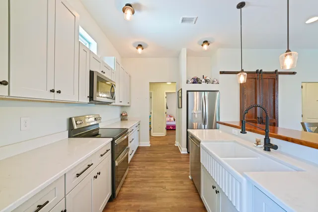 a kitchen with stainless steel appliances granite countertop a sink a stove and a refrigerator