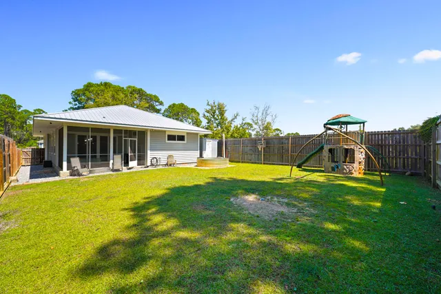 a view of a swimming pool with a patio and a yard