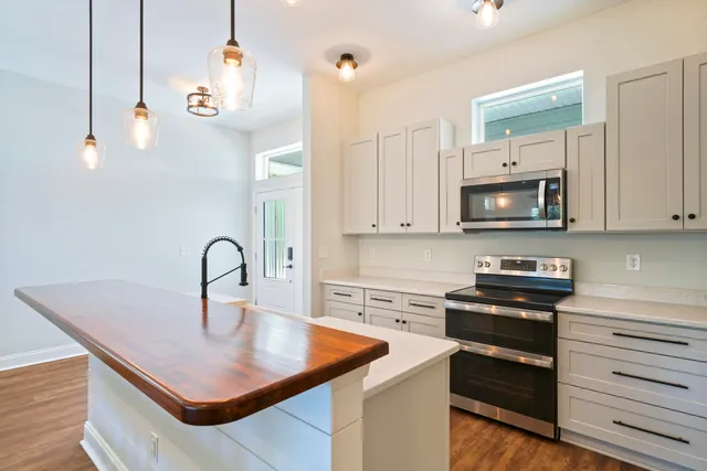 a kitchen with kitchen island a stove and a sink