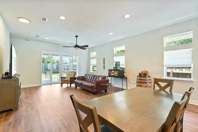 a living room with furniture a large window and wooden floor