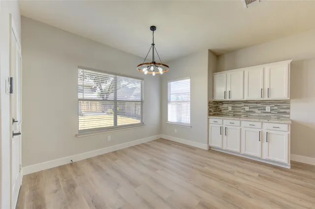 a kitchen with granite countertop white cabinets and window