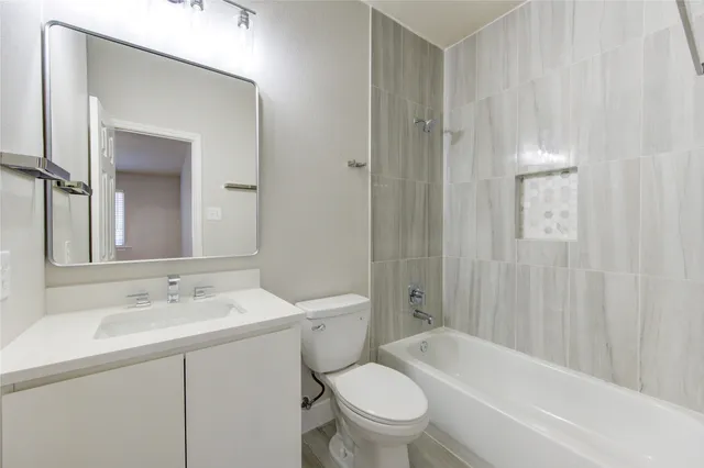 a bathroom with a sink toilet vanity and shower