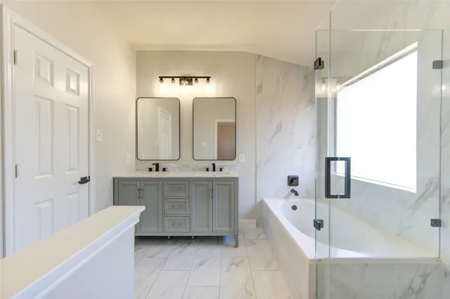a spacious bathroom with a double vanity sink a mirror and a bathtub