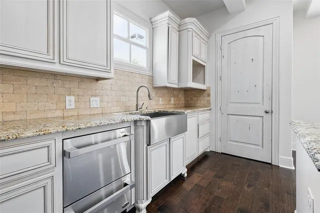 a kitchen with stainless steel appliances granite countertop white cabinets and a sink