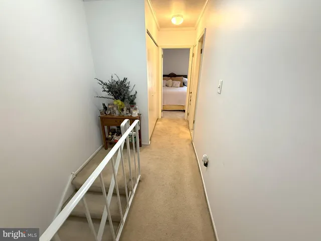 a view of a hallway with wooden floor and stairs