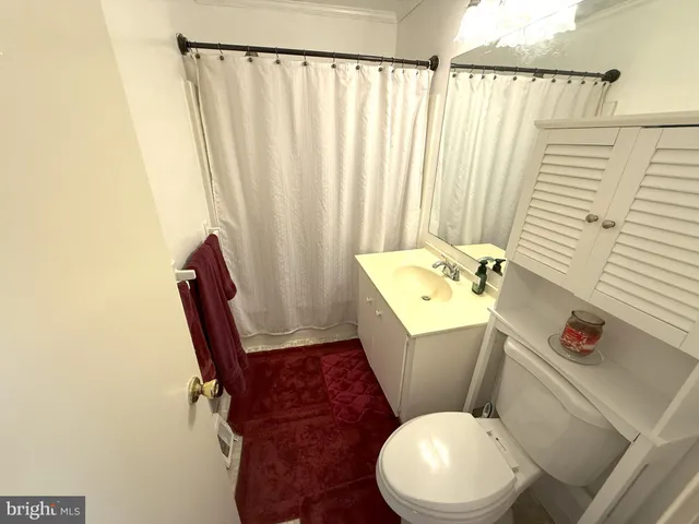 a white toilet sitting next to a bathroom sink and a window
