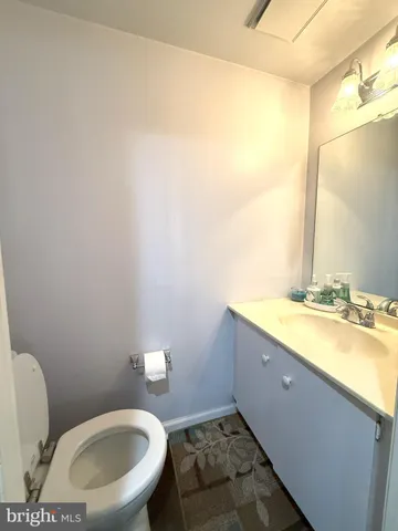a bathroom with a granite countertop sink a mirror and a toilet