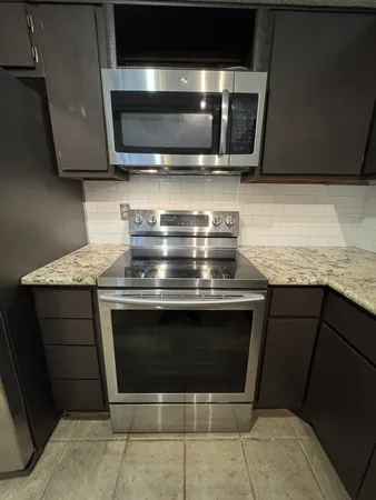 a stove top oven sitting inside of a kitchen