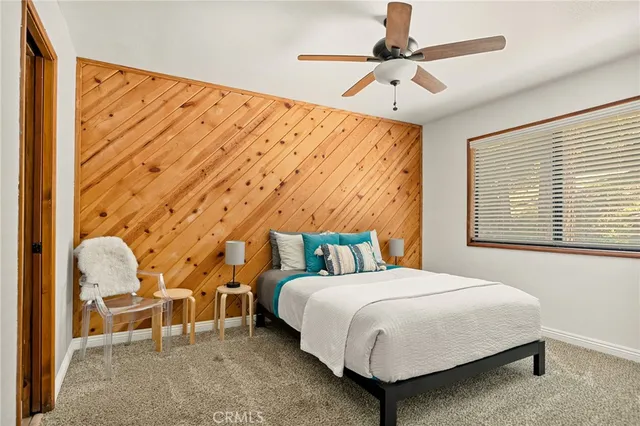 a bedroom with a bed a chair and a large window