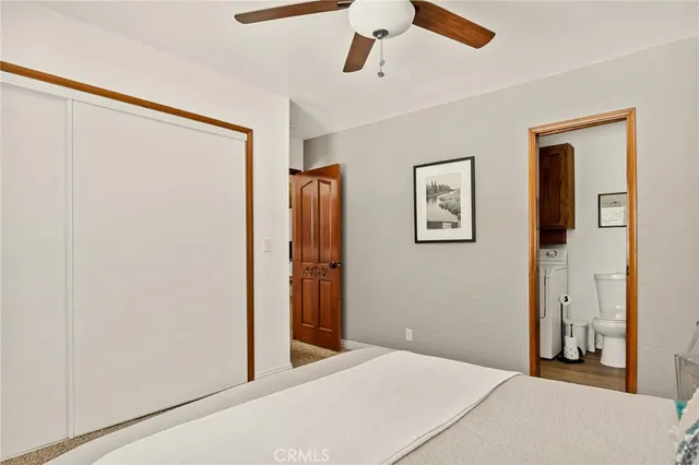 a bedroom with a bed and a refrigerator