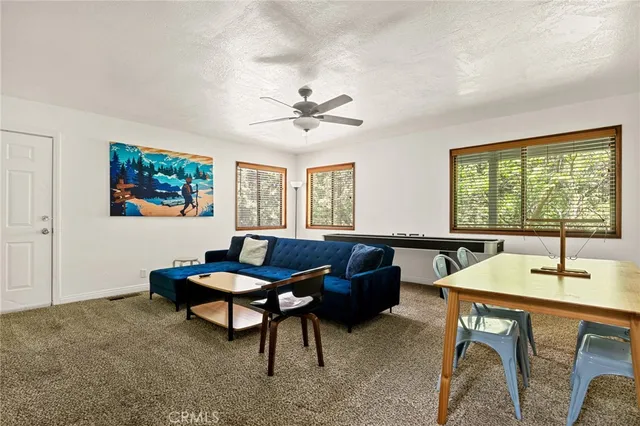 a living room with furniture a table and a large window