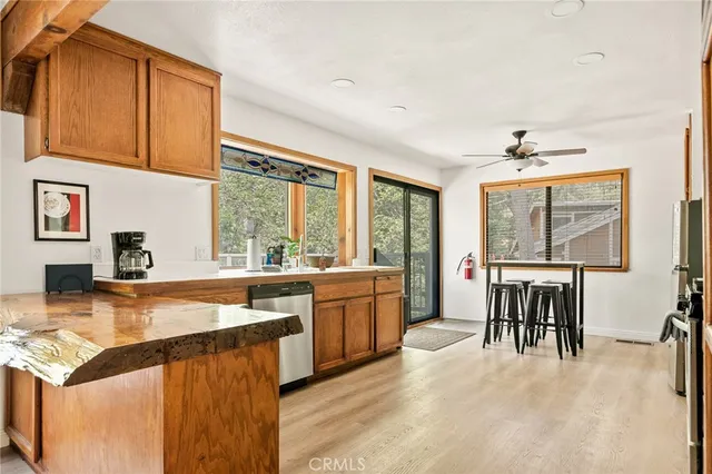 a large kitchen with kitchen island a large counter top space appliances and a large window