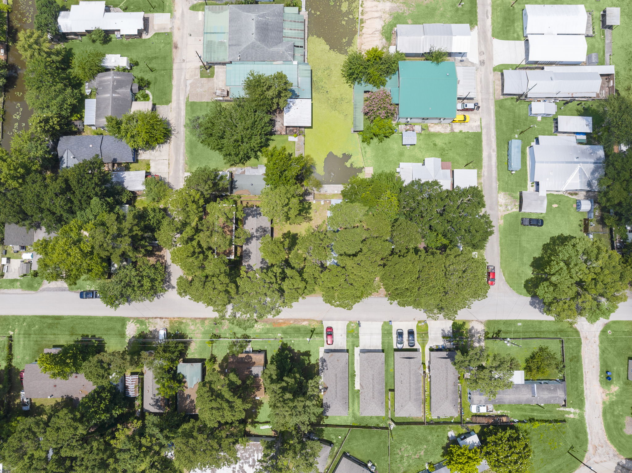 9649 Warm Spring Willis, TX 77318 - Photo 29 of 30 An aerial perspective reveals the neighborhood's layout, lush with mature trees and bordered by water features.