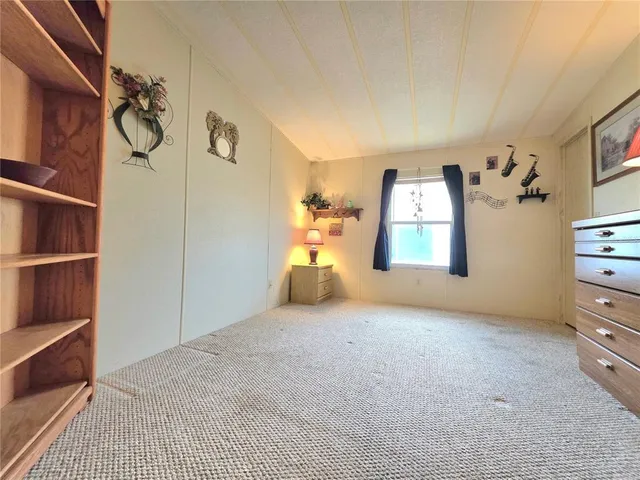 a view of a house with a big yard and a large trees