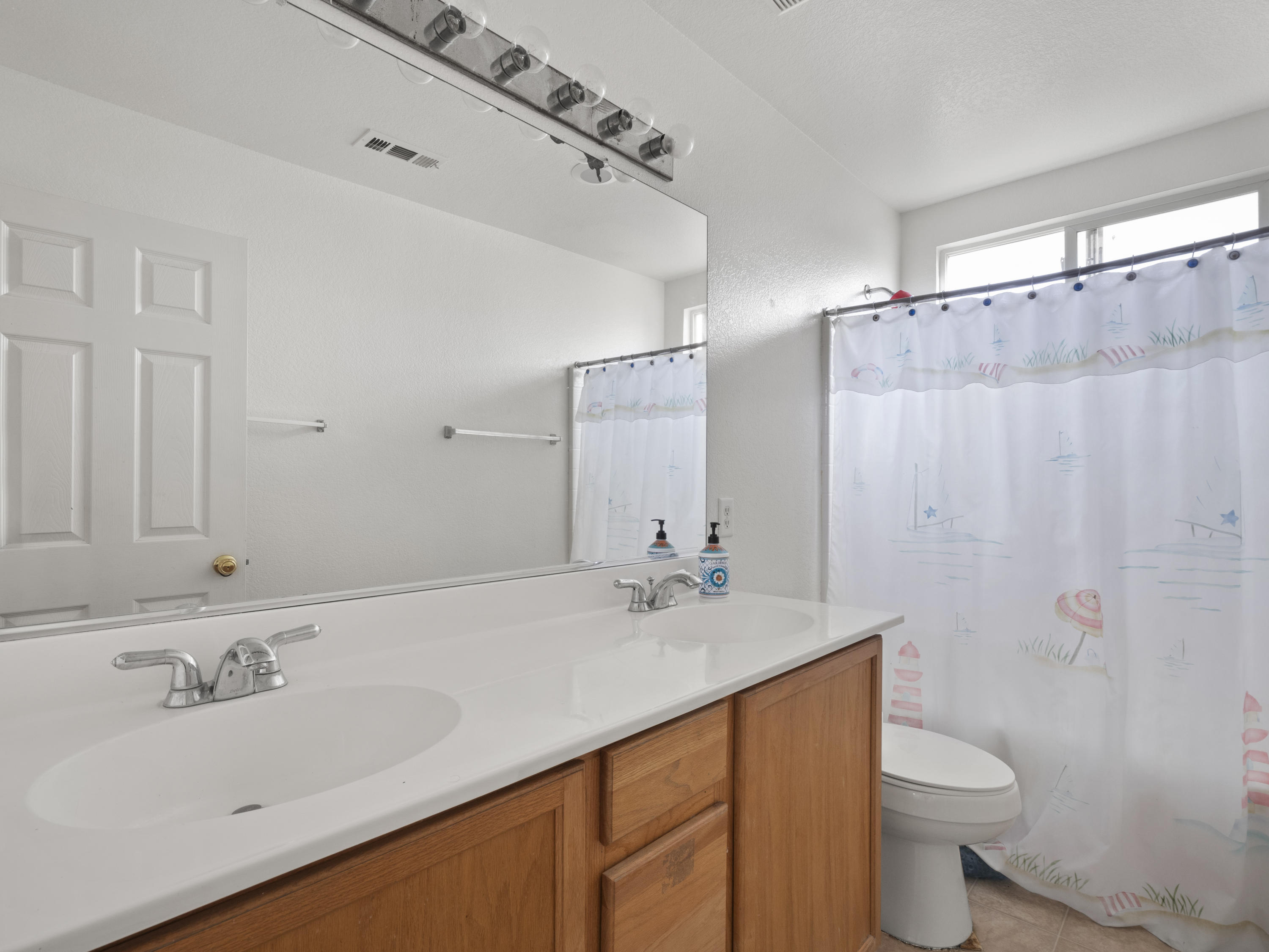 43635 Dana Drive Lancaster, CA 93535 - Photo 15 of 20 a bathroom with a sink a toilet and a mirror