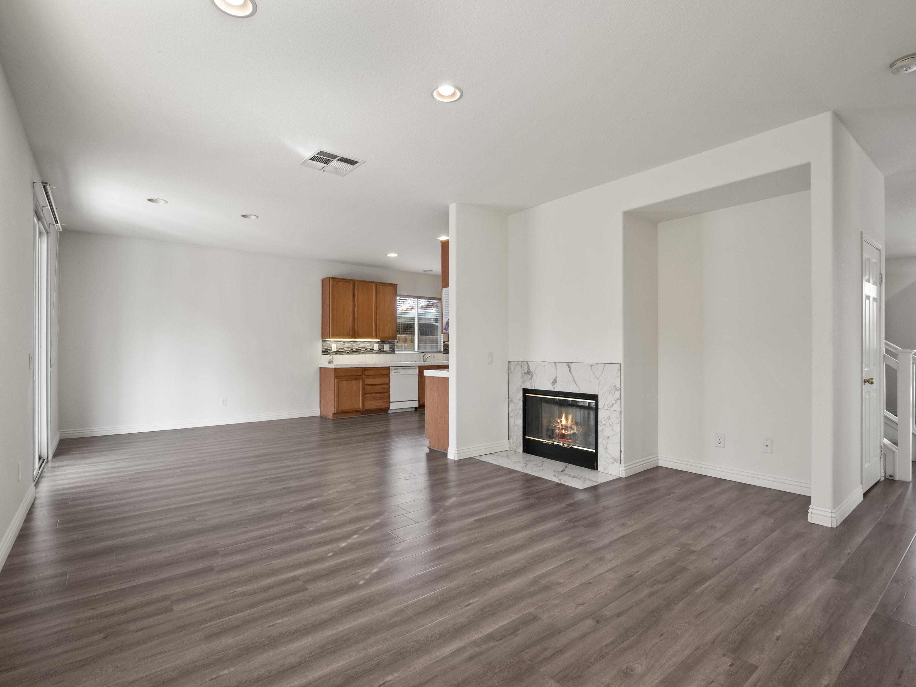 43635 Dana Drive Lancaster, CA 93535 - Photo 9 of 20 an empty room with wooden floor fireplace and windows
