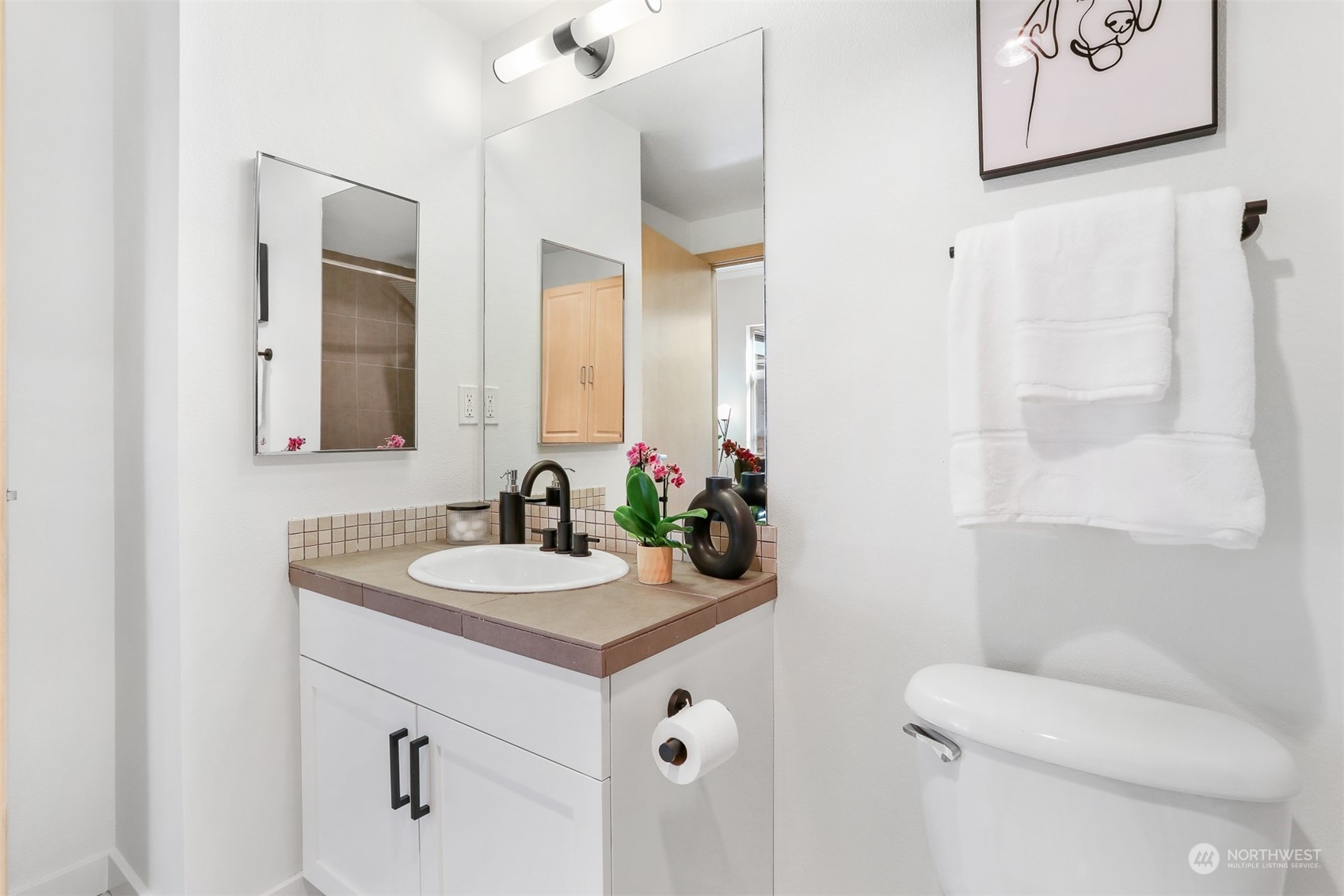 3333 Wallingford Avenue North, Unit 101 Seattle, WA 98103 - Photo 15 of 26 a bathroom with a sink vanity mirror and toilet