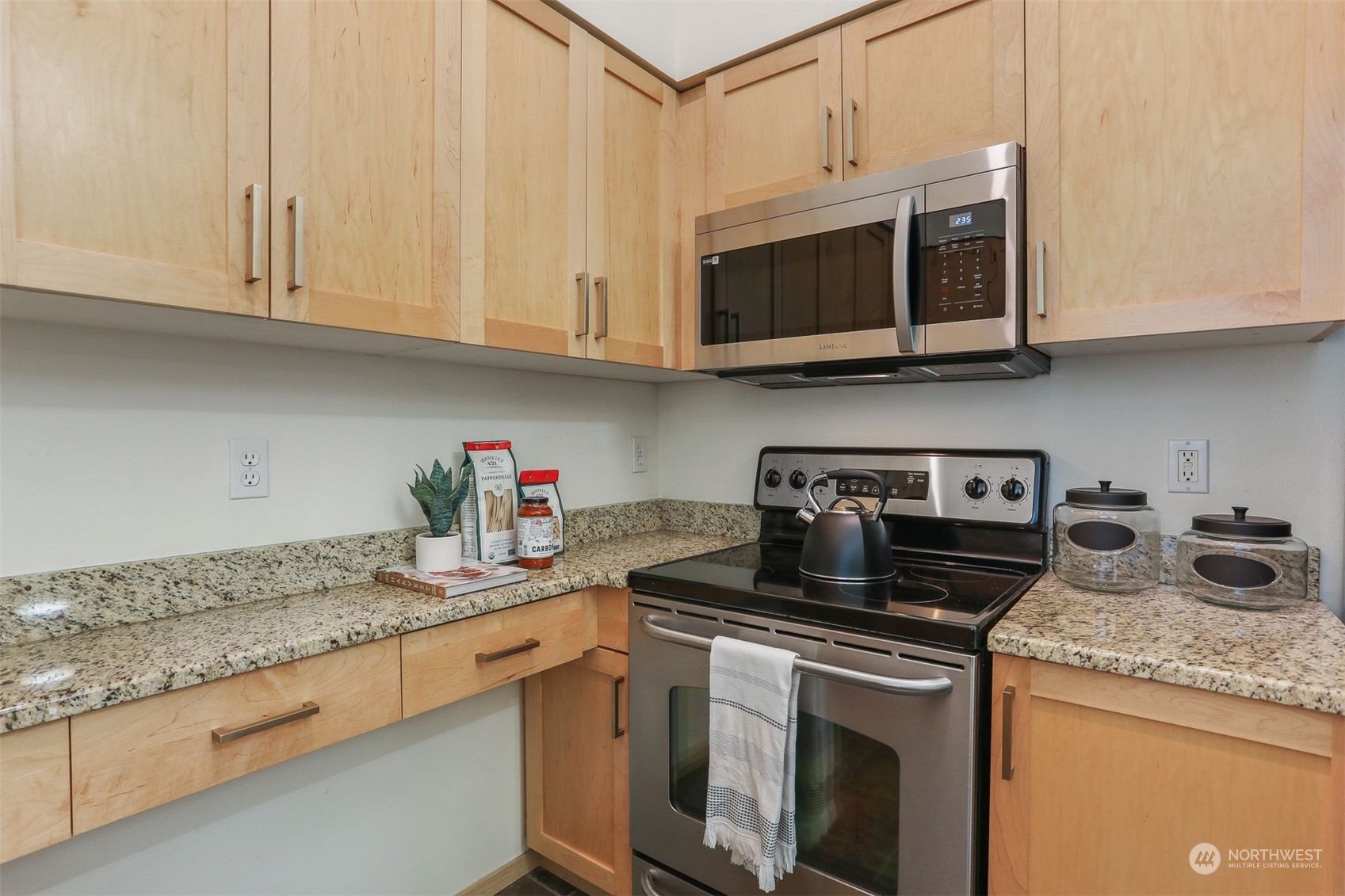 3333 Wallingford Avenue North, Unit 101 Seattle, WA 98103 - Photo 10 of 26 a kitchen with stainless steel appliances granite countertop white cabinets a stove a sink and dishwasher