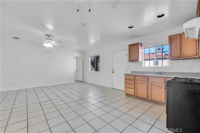 a kitchen with granite countertop a stove a sink and a window