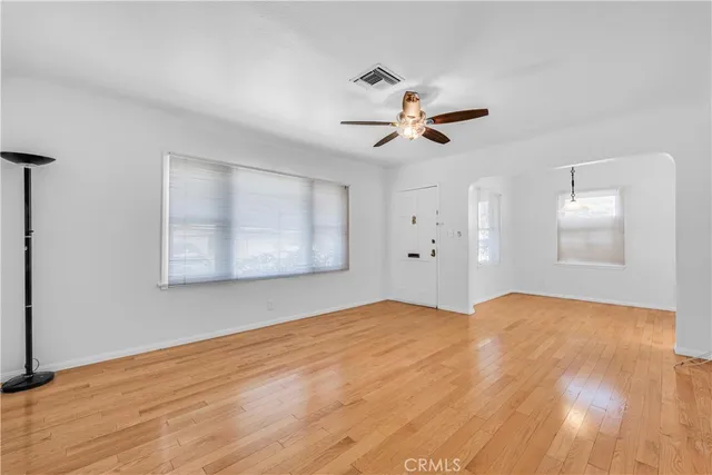 a view of an empty room with wooden floor