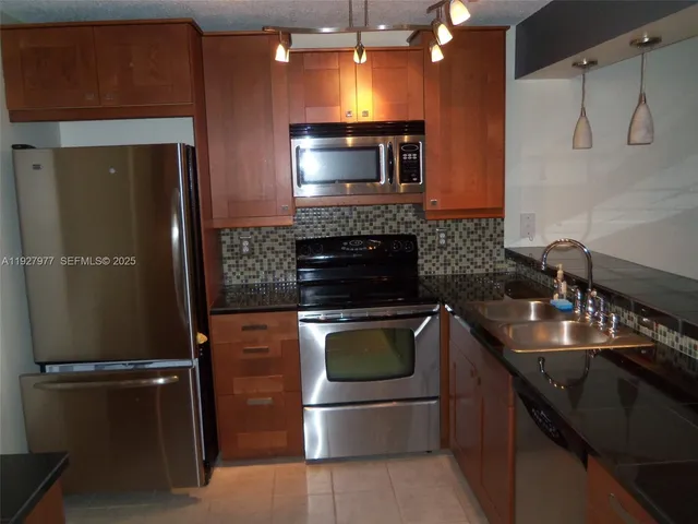 a kitchen with a sink and stainless steel appliances