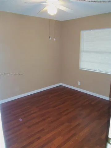 a view of a room with wooden floor and white walls
