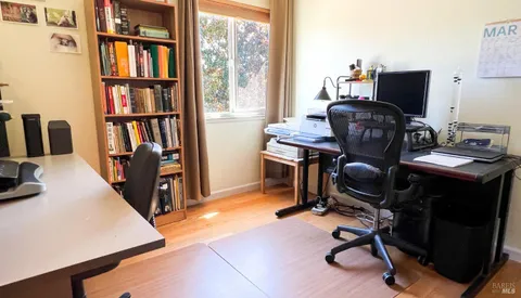 a view of a workspace with furniture and a window