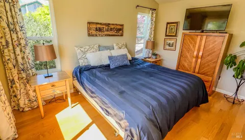 a bedroom with a bed and flat screen tv