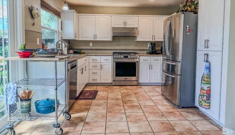 a kitchen with stainless steel appliances granite countertop a refrigerator and a stove