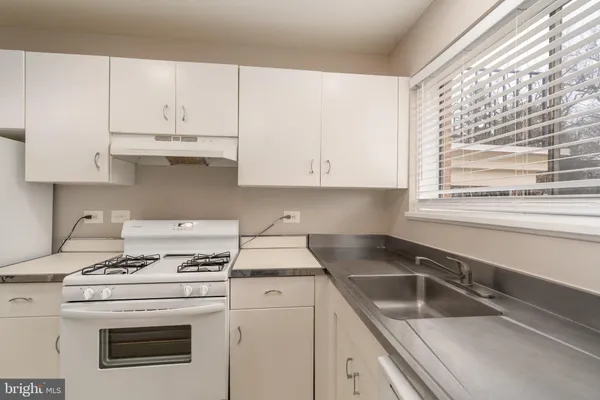 a kitchen with granite countertop white cabinets and white appliances