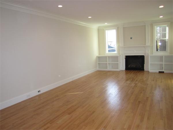 67 Hillcrest Road Waltham, MA 02451 - Photo 8 of 18 an empty room with wooden floor fireplace and windows