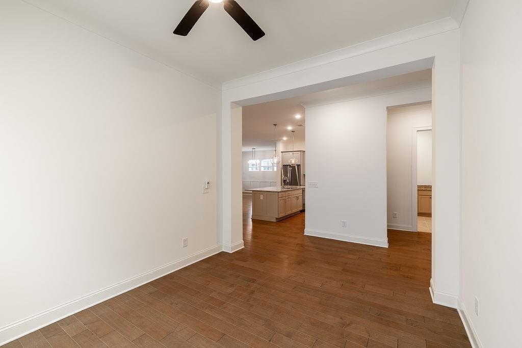 6954 Scenic Overlook Trace Flowery Branch, GA 30542 - Photo 14 of 55 an empty room with chandelier fan and kitchen view