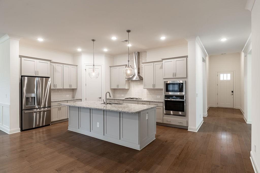 6954 Scenic Overlook Trace Flowery Branch, GA 30542 - Photo 15 of 55 a kitchen with stainless steel appliances granite countertop a refrigerator a stove and a sink