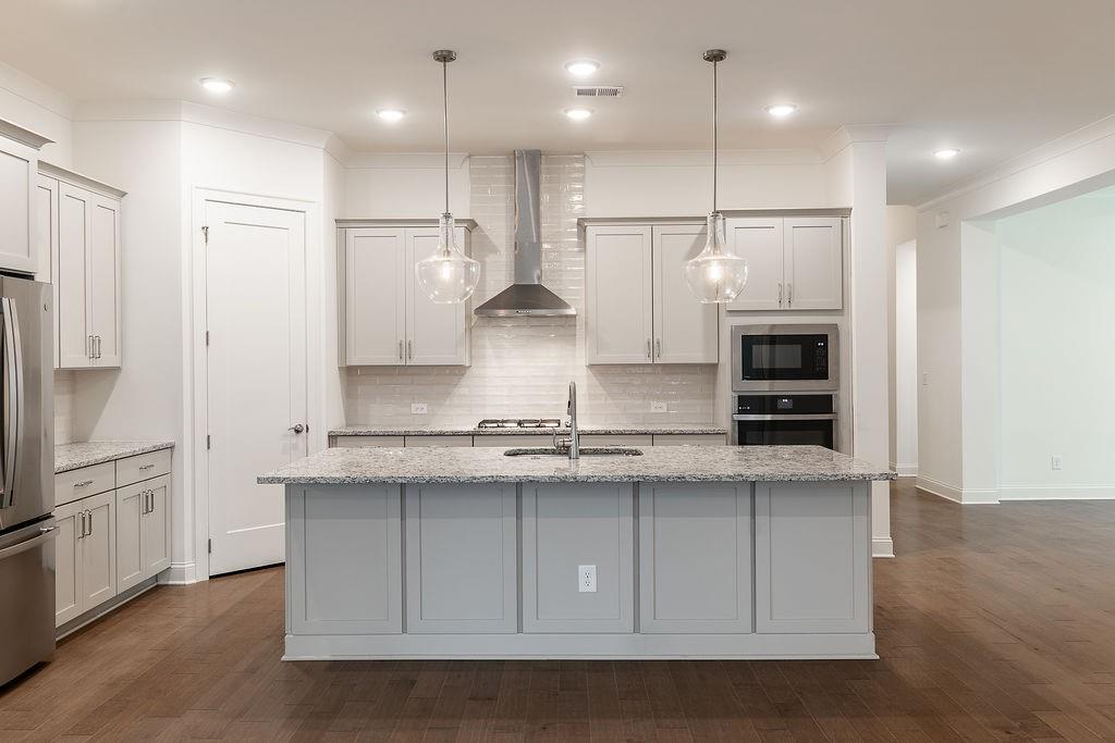 6954 Scenic Overlook Trace Flowery Branch, GA 30542 - Photo 16 of 55 a kitchen with stainless steel appliances granite countertop a sink a stove and a refrigerator