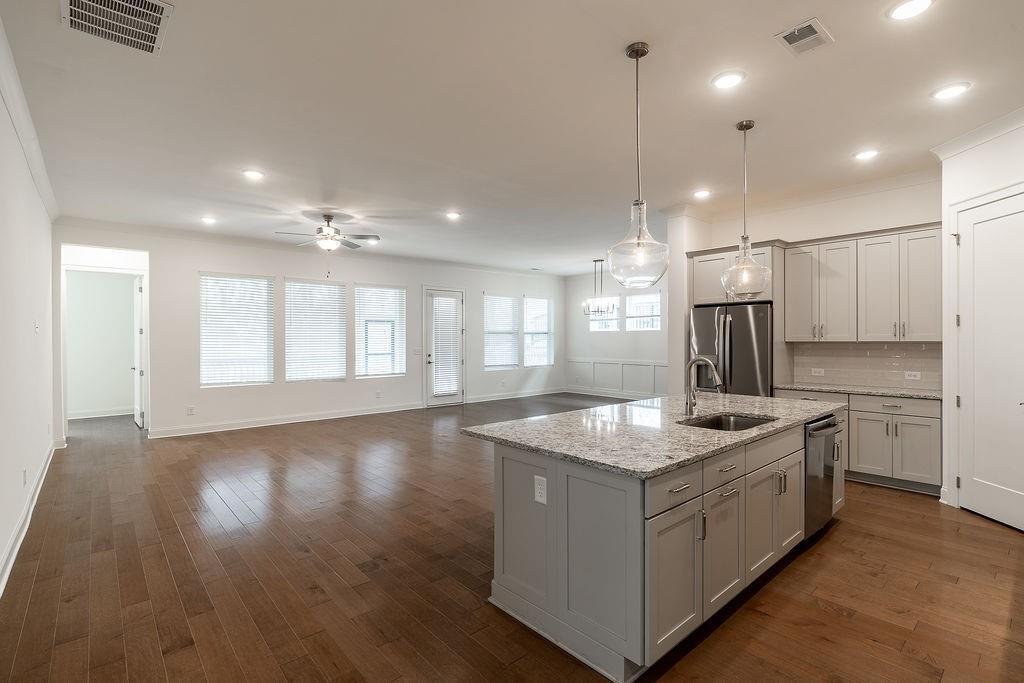 6954 Scenic Overlook Trace Flowery Branch, GA 30542 - Photo 19 of 55 a kitchen that has a lot of cabinets in it and wooden floors