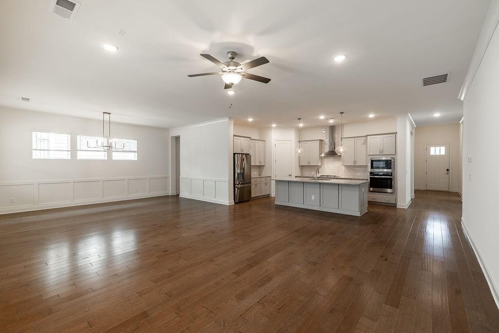 6954 Scenic Overlook Trace Flowery Branch, GA 30542 - Photo 21 of 55 a view of an empty room and kitchen with wooden floor