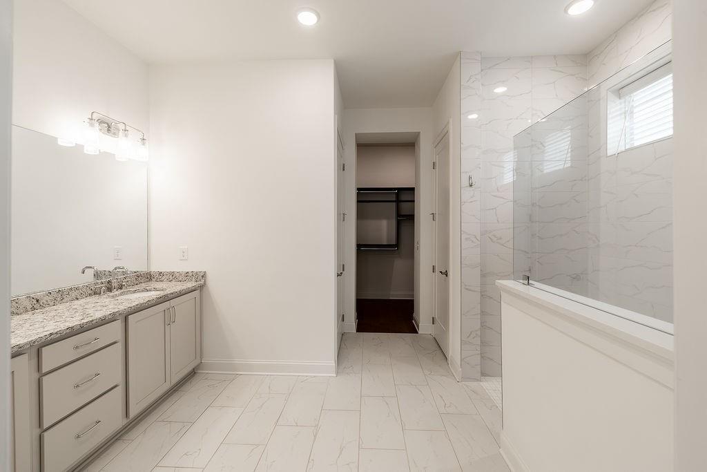 6954 Scenic Overlook Trace Flowery Branch, GA 30542 - Photo 28 of 55 a bathroom with a granite countertop sink a toilet and shower