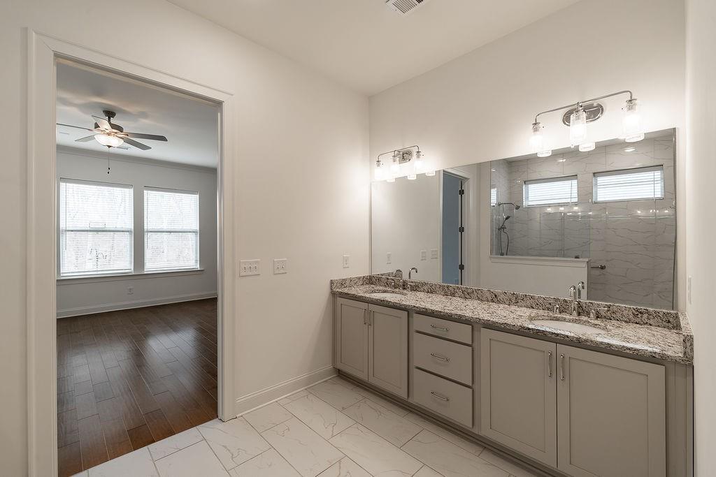 6954 Scenic Overlook Trace Flowery Branch, GA 30542 - Photo 29 of 55 a bathroom with a granite countertop sink a mirror and a shower